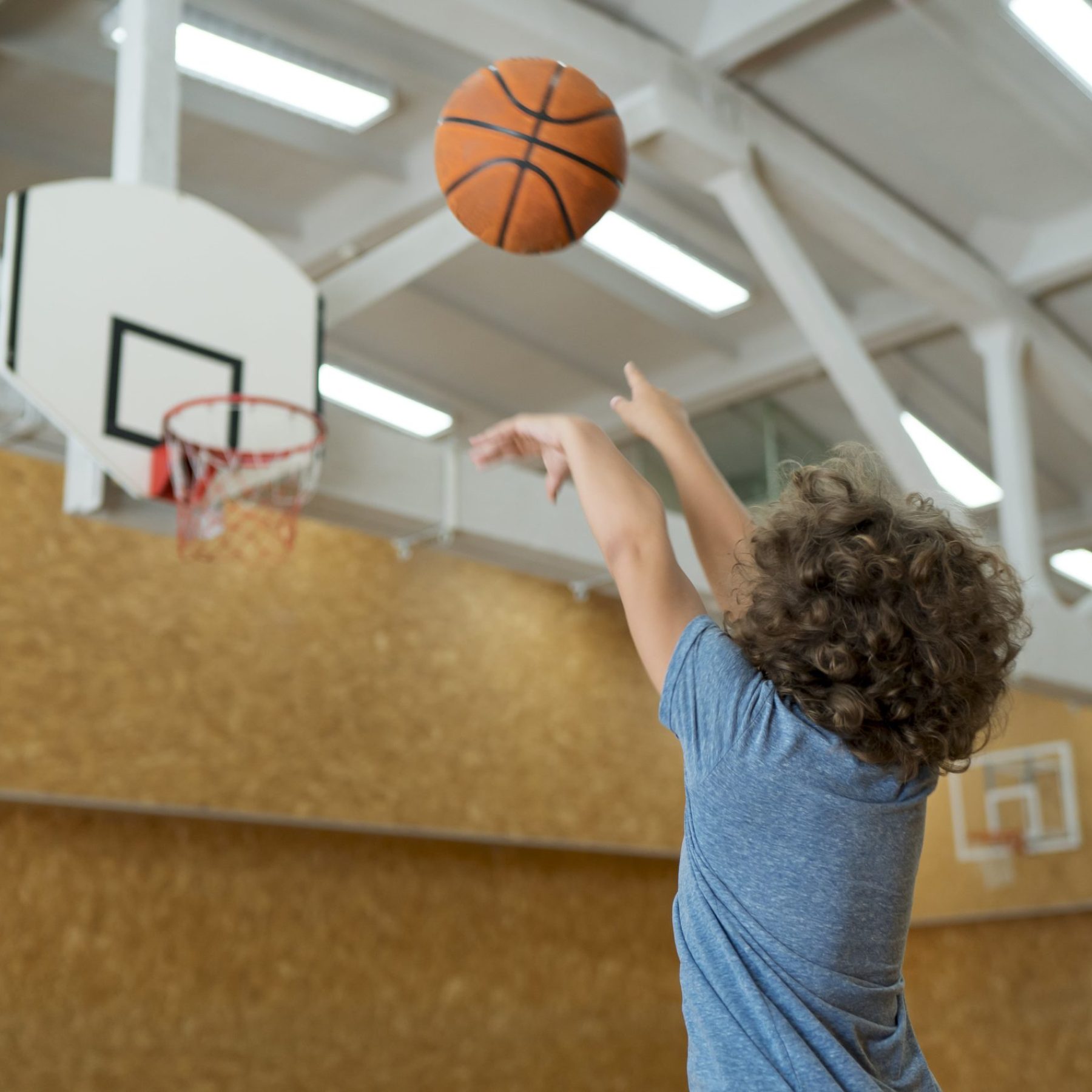 medium-shot-kid-throwing-basket-ball-min